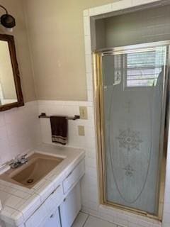 1305 SE 15th St, Wagoner, OK 74467 - full bathroom featuring a shower stall, vanity, tile walls, wainscoting, and tile patterned flooring