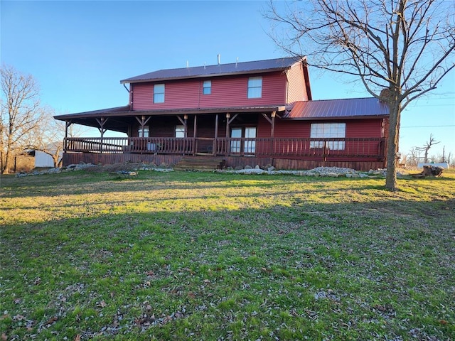 rear view of property featuring a lawn