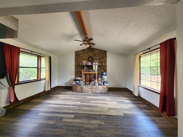 unfurnished living room with hardwood / wood-style floors, lofted ceiling with beams, and a wealth of natural light