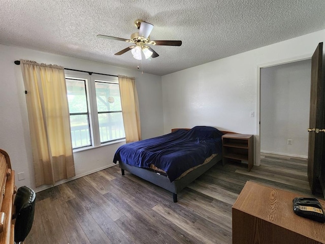 bedroom featuring a textured ceiling, ceiling fan, and dark wood-type flooring