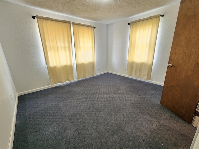 carpeted spare room featuring a textured ceiling