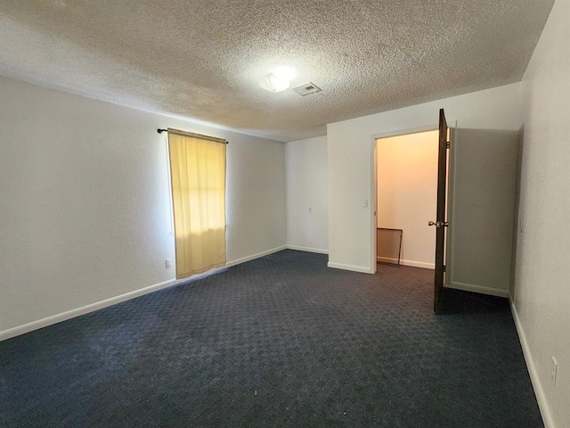 carpeted empty room with a textured ceiling