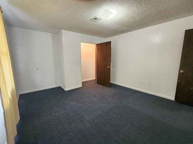 carpeted empty room featuring a textured ceiling