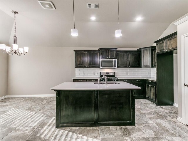 kitchen with tasteful backsplash, a kitchen island with sink, stainless steel appliances, and vaulted ceiling