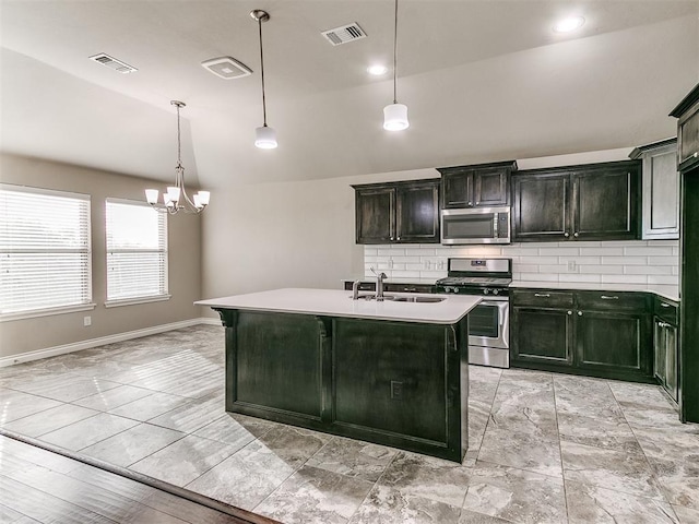 kitchen featuring appliances with stainless steel finishes, a kitchen island with sink, sink, an inviting chandelier, and lofted ceiling