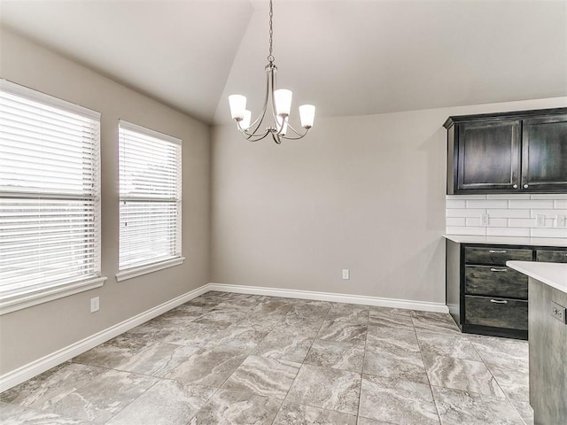 unfurnished dining area featuring an inviting chandelier and lofted ceiling