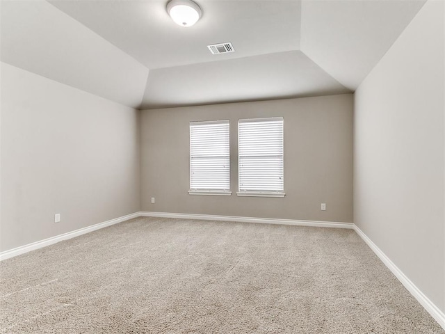 carpeted empty room featuring vaulted ceiling