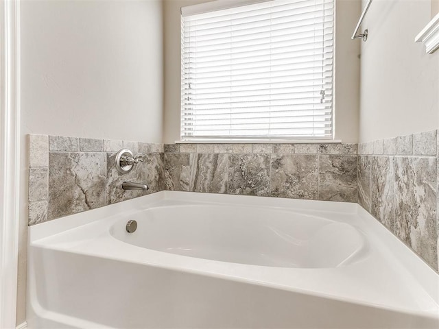 bathroom with a washtub and a healthy amount of sunlight