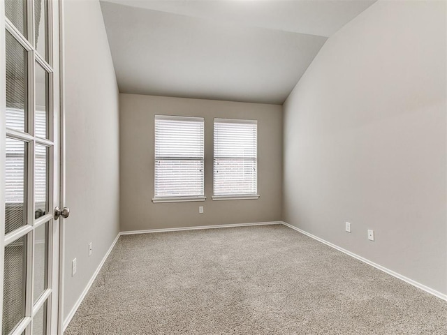 unfurnished room featuring carpet and vaulted ceiling