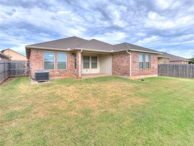 back of house with a lawn, cooling unit, and a patio