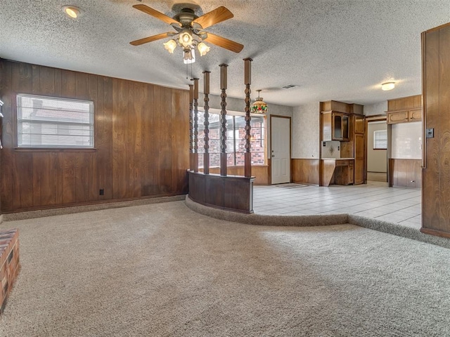 unfurnished living room featuring wooden walls and a healthy amount of sunlight