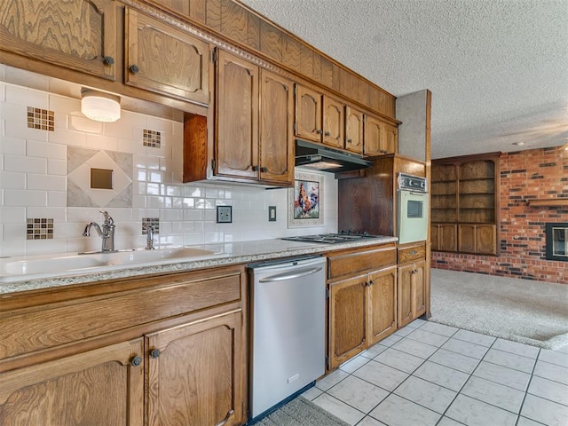 kitchen with sink, stainless steel appliances, tasteful backsplash, a textured ceiling, and light tile patterned floors