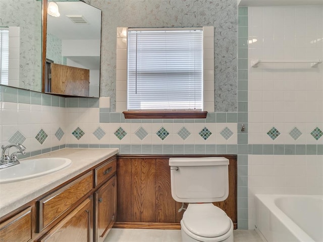 bathroom with a tub to relax in, toilet, tile walls, and a healthy amount of sunlight