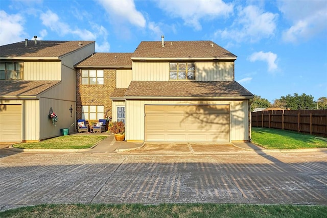 rear view of property featuring a garage and a lawn