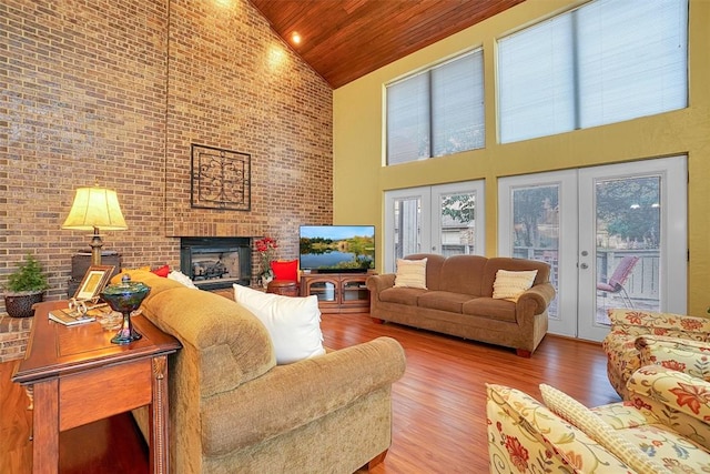 living room featuring french doors, wood-type flooring, high vaulted ceiling, wooden ceiling, and a fireplace