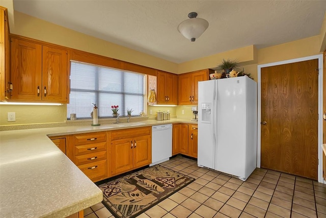 kitchen featuring white appliances, sink, and light tile patterned floors