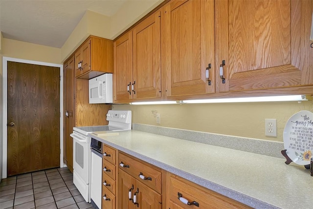 kitchen with white appliances and light tile patterned floors