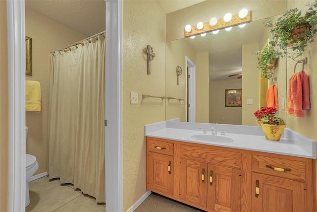 bathroom featuring tile patterned floors, ceiling fan, vanity, and toilet