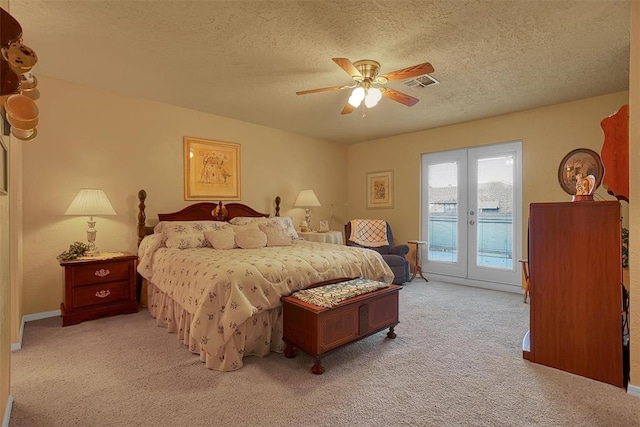 carpeted bedroom with ceiling fan, access to exterior, a textured ceiling, and french doors