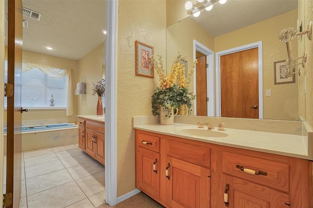 bathroom featuring tile patterned flooring, vanity, and a tub