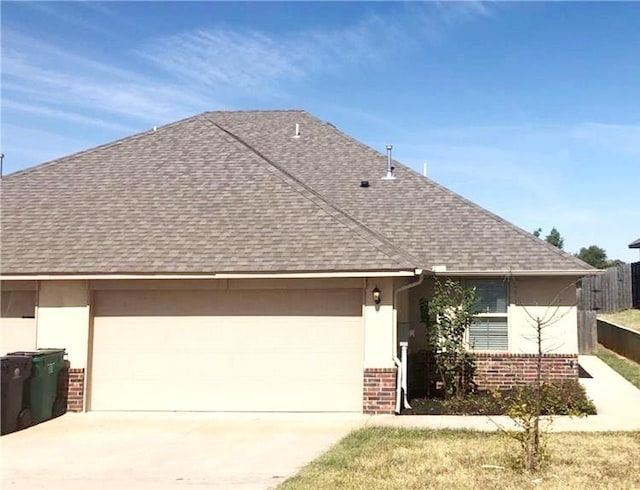 11221 Coachmans Rd, Yukon, OK 73099 - view of front of home featuring brick siding, roof with shingles, an attached garage, and driveway