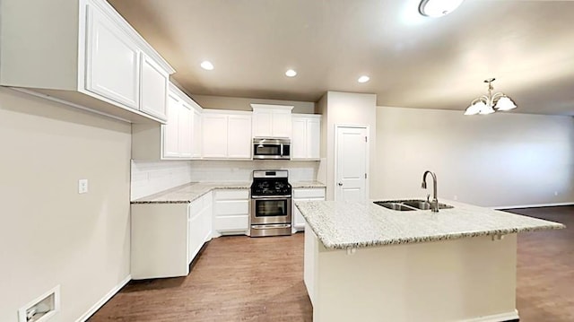 11221 Coachmans Rd, Yukon, OK 73099 - kitchen with stainless steel appliances, tasteful backsplash, a chandelier, white cabinets, and wood finished floors