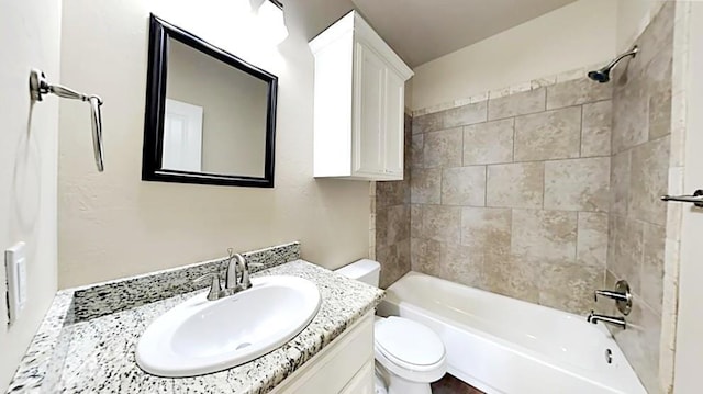 full bathroom with vanity, tiled shower / bath, and toilet