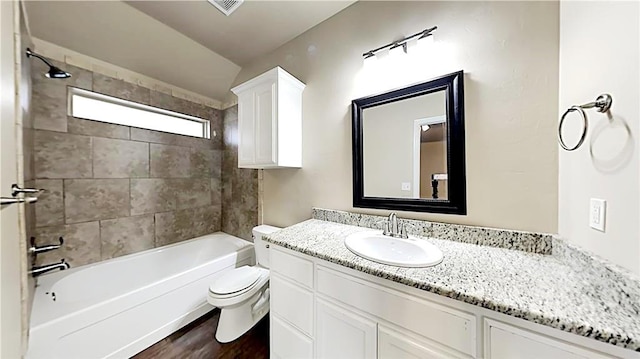 full bathroom with vanity, toilet, tiled shower / bath, and hardwood / wood-style flooring