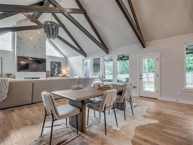 dining area featuring a chandelier, beam ceiling, light wood-type flooring, and high vaulted ceiling