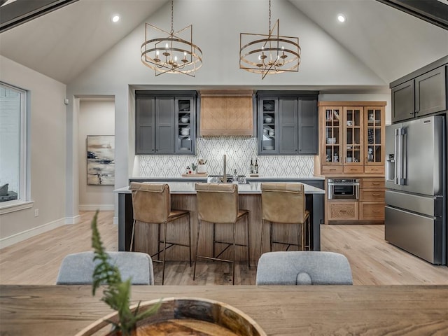 kitchen featuring a center island, high vaulted ceiling, a chandelier, decorative light fixtures, and high quality fridge