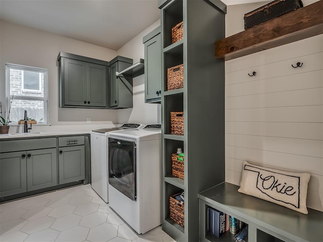 washroom featuring cabinets, light tile patterned floors, washing machine and clothes dryer, and sink