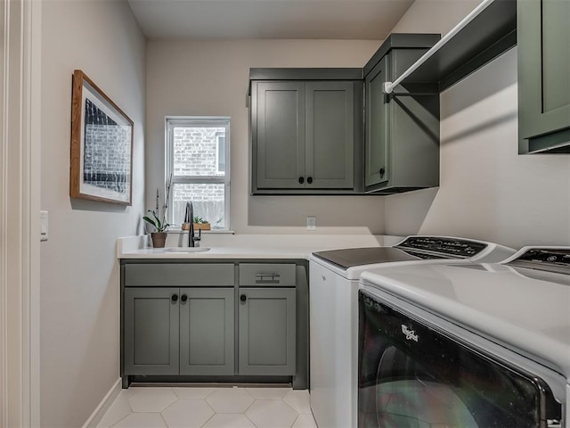 clothes washing area with cabinets, sink, and washer and dryer