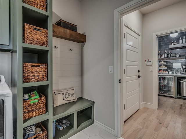 mudroom featuring wine cooler, light hardwood / wood-style flooring, and washer / dryer