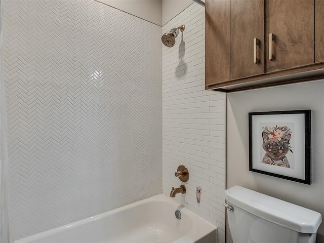 bathroom with tiled shower / bath combo and toilet