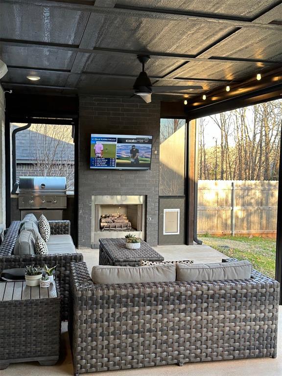 view of patio with ceiling fan, area for grilling, and an outdoor fireplace