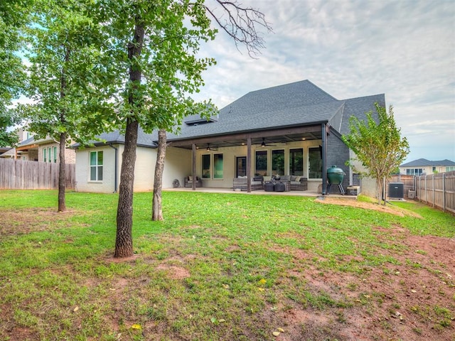 back of property with a patio, central air condition unit, ceiling fan, and a lawn