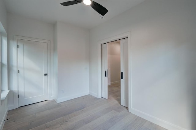 unfurnished bedroom with light wood-type flooring, baseboards, and a ceiling fan