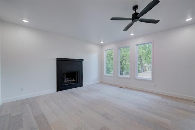 unfurnished living room featuring a fireplace, light wood finished floors, recessed lighting, visible vents, and baseboards