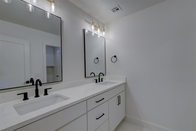 bathroom featuring double vanity, baseboards, visible vents, and a sink