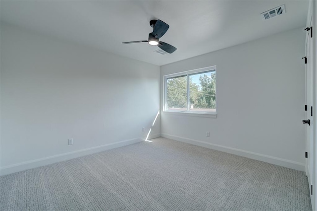 empty room featuring baseboards, visible vents, and light colored carpet