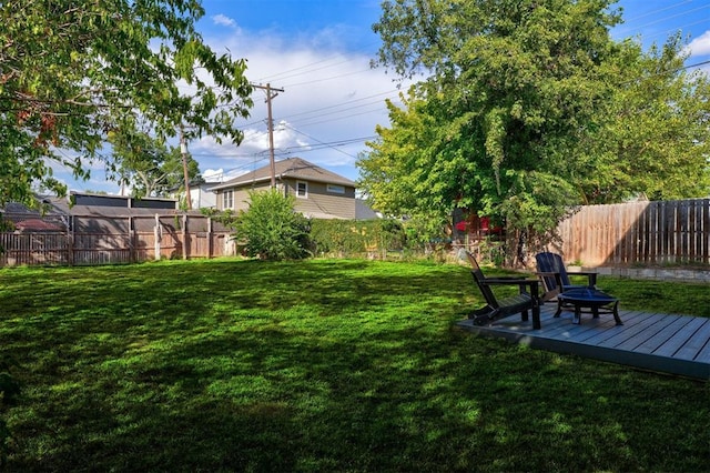 view of yard featuring a fenced backyard and a fire pit