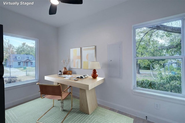 home office with ceiling fan, electric panel, and baseboards