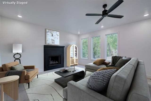 living area featuring a ceiling fan, recessed lighting, a fireplace, and baseboards