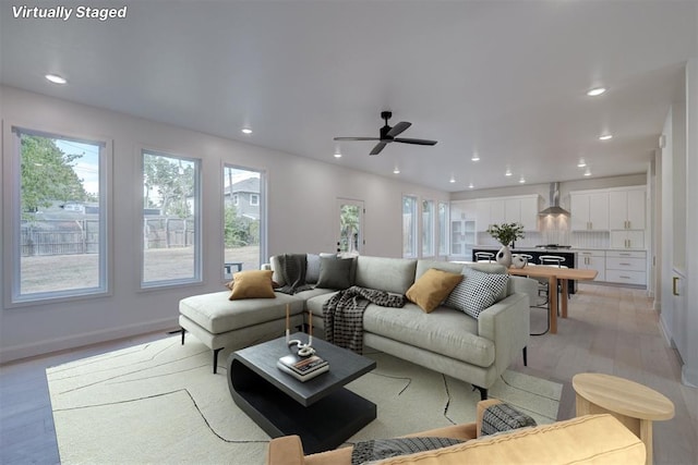 living room with ceiling fan, light wood-style flooring, and recessed lighting