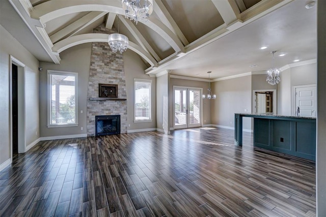 unfurnished living room with dark hardwood / wood-style flooring, a stone fireplace, plenty of natural light, and ornamental molding