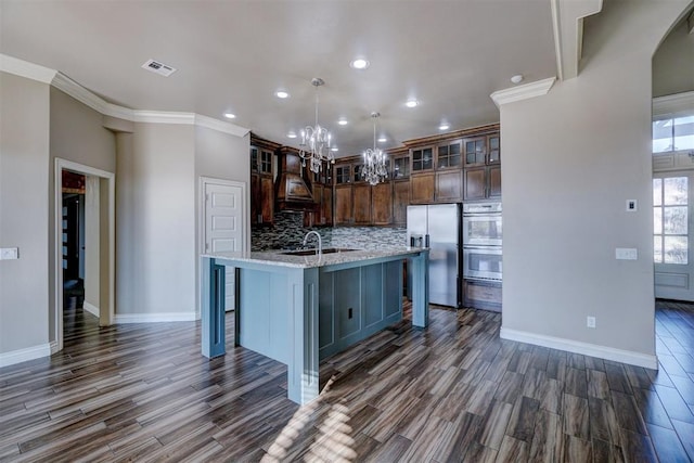 kitchen featuring a center island with sink, dark wood-type flooring, and appliances with stainless steel finishes