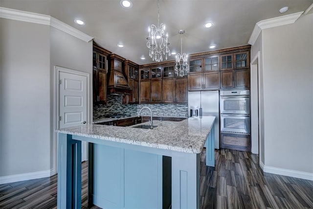 kitchen featuring sink, stainless steel appliances, tasteful backsplash, light stone counters, and dark brown cabinets