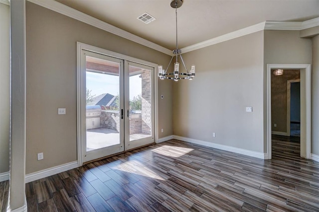 unfurnished dining area with a chandelier, ornamental molding, french doors, and dark wood-type flooring