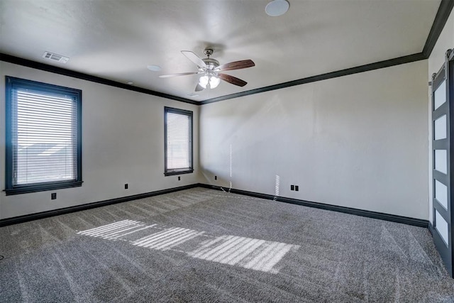 carpeted spare room with ceiling fan, ornamental molding, and a wealth of natural light