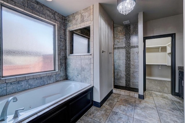 bathroom featuring tile patterned floors, plenty of natural light, a tub, and a notable chandelier